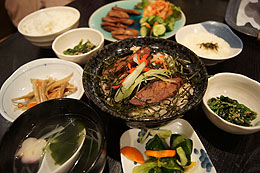 写真：牛タン丼を中心に、テーブルいっぱいに並べられた料理